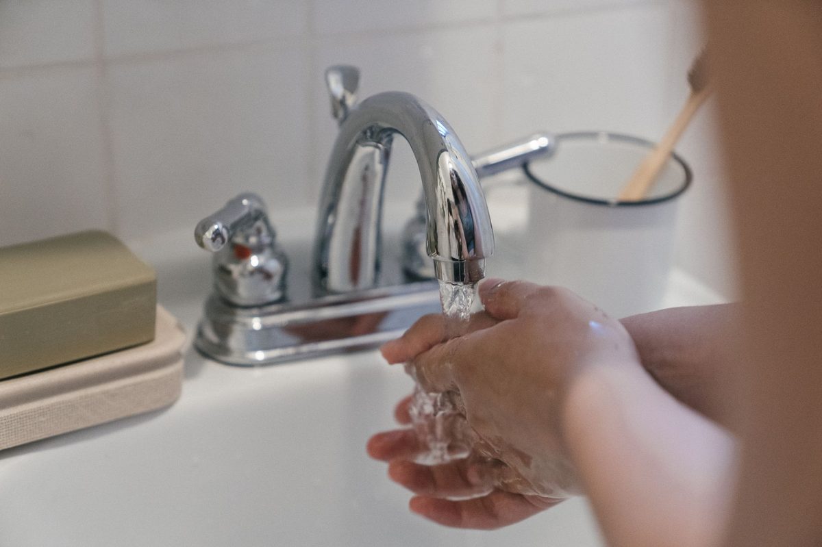 Руки под тёплой водой над раковиной, средство смывают без трения